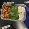 Nutritious meal box with rice, chicken, and spinach for macronutrient balance and muscle support.