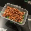 Healthy meal prep with shredded chicken, pasta, and peas for muscle building.