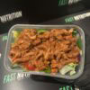 Healthy high-protein meal featuring cooked chicken and fresh vegetables in a ready-to-eat container.
