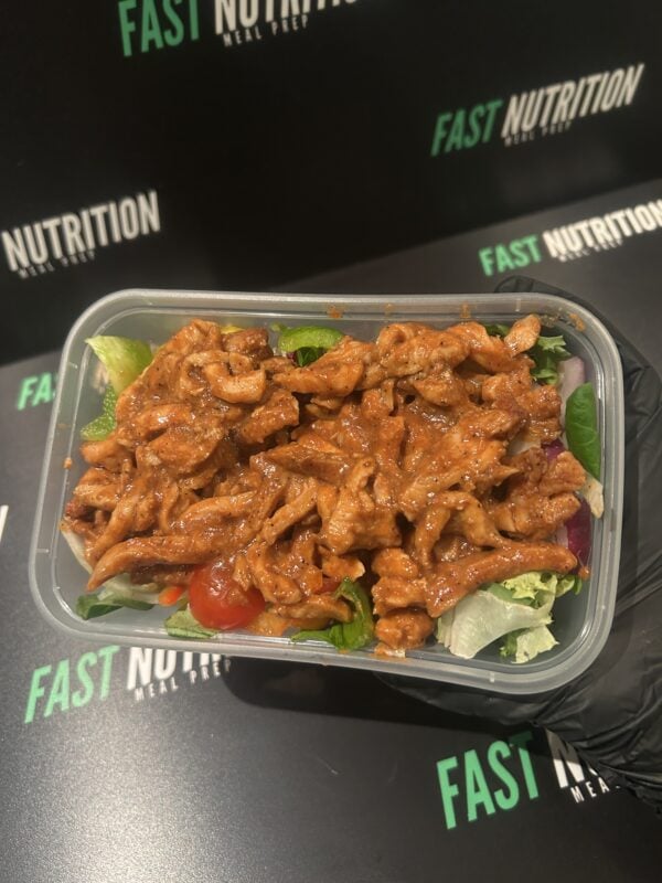 Healthy high-protein meal featuring cooked chicken and fresh vegetables in a ready-to-eat container.