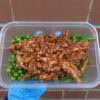 Healthy protein meal with green beans and peas in a meal prep container.