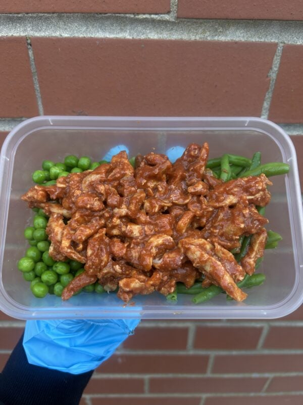 Healthy protein meal with green beans and peas in a meal prep container.