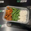 Nutritious chicken, green beans, and rice in meal container for fitness meal prep.