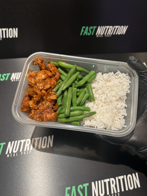 Nutritious chicken, green beans, and rice in meal container for fitness meal prep.