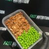 Healthy protein meal prep with cooked meat and green peas for fitness.